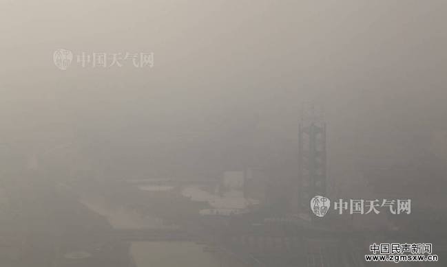 12月19日早晨，北京持续空气重污染，记者登上246.8米高的北京奥林匹克塔，鸟瞰北京城，发现咫尺之遥的鸟巢、水立方等奥运场馆和城市地标建筑被霾“吞没”，消失不见。图为鸟巢。（摄影：关禺）